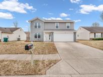 Charming two-story home with gray siding, a two-car garage, and a well-manicured lawn at 878 Hollowood Ln, Avon, IN 46123
