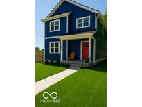 Charming two-story home featuring a blue exterior with a red front door and well-manicured lawn at 1305 W 23Rd St, Indianapolis, IN 46208