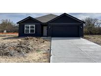 New construction with dark siding, concrete driveway, and attached two car garage at 1704 N Winthrop Rd, Muncie, IN 47304