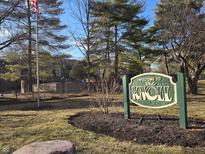 Welcome to The Knoll community sign with manicured lawn and mature trees creates a warm inviting atmosphere at 2207 Rome Dr # B, Indianapolis, IN 46228