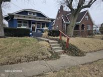 Charming blue two-story home with landscaped yard and inviting front porch at 2255 E Riverside Dr, Indianapolis, IN 46208