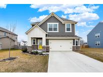 Charming two-story home with gray siding, brick accents, manicured lawn, and a bright yellow front door at 2705 Grassy Branch Dr, Whitestown, IN 46075