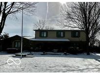 Charming two-story home featuring a well-maintained lawn covered in snow and classic architectural details at 296 Ironwood Ct, Carmel, IN 46033