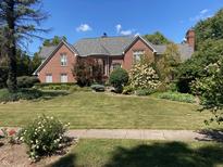 Beautiful brick home with a manicured lawn and mature landscaping on a sunny day at 3370 Walnut Creek Ct, Carmel, IN 46032