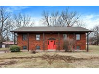 Two story red brick home with a covered porch and bright red front door at 4344 S Lynhurst Dr, Indianapolis, IN 46221