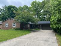 Charming brick ranch with an attached two-car garage and mature landscaping at 530 Lansdowne Rd, Indianapolis, IN 46234