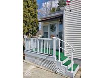Charming front porch with a white railing, green turf, and decor at 5317 E 20Th Pl, Indianapolis, IN 46218