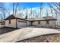 Charming one story home with a brick exterior, attached garage, and a well manicured front yard at 6775 W Woodcrest Dr, Greenfield, IN 46140