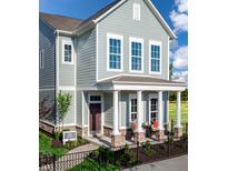 Charming two-story home featuring a covered porch with stone accents and a well-manicured front yard at 746 Astor Dr, Carmel, IN 46032