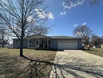 Charming single-story home with light-blue siding, a covered front porch, and an attached two-car garage at 7610 Brehob Rd, Indianapolis, IN 46217