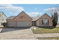 Charming brick home featuring an attached two-car garage and manicured front yard at 8535 Fenton Tower Dr, Indianapolis, IN 46259