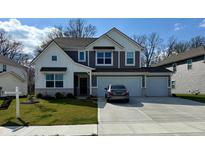 Charming two-story home with a three car garage, lush green lawn and grey exterior paint at 8623 Lester Pl, Pendleton, IN 46064