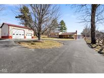 Property view showcasing a large driveway, an auxiliary garage, and a ranch style home at 1001 N 750 W, Bargersville, IN 46106