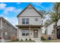 Charming two-story home featuring a quaint front porch and beautifully landscaped yard at 206 N Hamilton Ave, Indianapolis, IN 46201