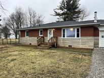 Charming single-story brick home featuring stone accents, a quaint front porch, and a well-maintained yard at 2070 E 100 S, Lebanon, IN 46052