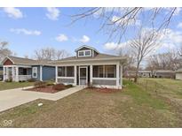 Charming home featuring a screened porch, well-maintained landscaping, and inviting curb appeal at 2868 Tindall St, Indianapolis, IN 46203