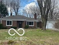 Charming brick ranch home with a well-maintained lawn and mature trees at 3233 E 48Th St, Indianapolis, IN 46205