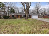 Charming one-story brick home featuring a well-manicured lawn and attached two-car garage at 3233 E 48Th St, Indianapolis, IN 46205