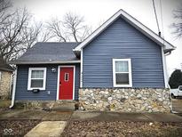Charming home featuring blue siding, stone accents, a bright red door and well-maintained landscaping at 422 Johnson Ave, Franklin, IN 46131