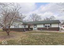 Charming single-story home featuring light green siding, brick accents, and a well-maintained front yard at 4758 Runyon Lake Dr, Greenwood, IN 46143