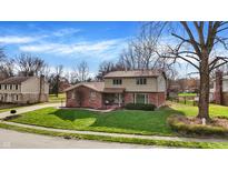 Two-story home with a well-maintained lawn, mature trees, and a brick and vinyl exterior at 502 Ironwood Dr, Carmel, IN 46033