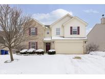 Two-story home showcasing brick and siding, with a two-car garage and snow-covered landscaping at 5134 Greenside Dr, Indianapolis, IN 46235
