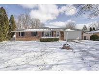 Charming single-story brick home featuring an attached garage and snow-covered front yard at 5818 S Madison Ave, Anderson, IN 46013