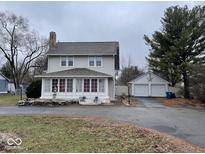 Charming two-story home features a large yard and detached two car garage at 6601 Rockville Rd, Indianapolis, IN 46214