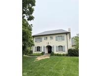 Charming two-story home featuring a light brick exterior, gray shutters, and a well-manicured lawn at 7525 N Pennsylvania St, Indianapolis, IN 46240