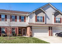 Charming townhome featuring red shutters, a two-car garage, and well-maintained landscaping at 10246 Eller Creek Dr, Fishers, IN 46038