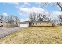Ranch-style home featuring a brick facade, attached garage, and a well-maintained front lawn at 10777 Bradley Dr, Indianapolis, IN 46231