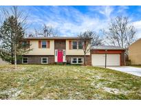 Two story home with brick and vinyl siding, attached garage, and bright pink front door at 11809 Wainwright Blvd, Fishers, IN 46038