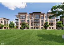 Beautiful four-story building featuring brick facade, balconies, and a large lawn at 15 W Executive Dr # 104, Carmel, IN 46032