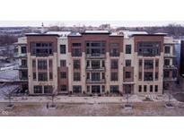 Modern condo building with brick and wood facade, featuring large windows and private balconies at 15 W Executive Dr # 104, Carmel, IN 46032