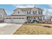 Inviting two-story home featuring a brick facade, covered porch, and three-car garage at 18819 Dooney Ct, Noblesville, IN 46062
