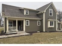 Charming home featuring vertical siding, a covered porch, and well-maintained landscaping at 307 S Main St, Whitestown, IN 46075