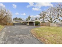 Ranch style home with long driveway, mature trees, neutral color palette, and attached garage at 3645 Glencairn Ln, Indianapolis, IN 46205