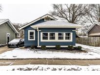 Charming blue home featuring a well-maintained lawn and a cozy covered porch at 3708 Rockville Rd, Indianapolis, IN 46222