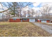 Charming single story brick home featuring a front yard, garage and gravel driveway at 4018 S State Road 75, Coatesville, IN 46121