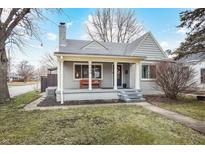 Inviting home showcasing a covered front porch, neat landscaping, and a secure ADT security sign at 5240 E 10Th St, Indianapolis, IN 46219