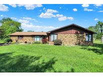 Charming ranch home with stone facade and well-maintained lawn under a partly cloudy sky at 5272 N Graham Rd, Whiteland, IN 46184