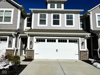 Beautiful exterior elevation view of a gray townhome with an attached two-car garage and a concrete driveway at 9634 Beckett St, Avon, IN 46123