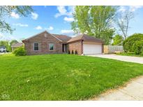 Beautiful single-story brick home with a green lawn and mature trees at 1135 Sherwood Dr, Danville, IN 46122