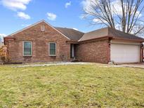 Charming brick home featuring a well-manicured lawn and attached garage at 1135 Sherwood Dr, Danville, IN 46122