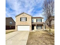 Charming two-story home boasts a brick facade, attached two-car garage, and inviting front porch at 11852 Geyser Ct, Fishers, IN 46038
