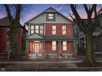 Charming red brick two-story home with a welcoming front porch and professionally landscaped front yard at 235 E 11Th St, Indianapolis, IN 46202