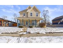 Charming two-story home featuring a welcoming front porch and classic architectural details at 2605 Carrollton Ave, Indianapolis, IN 46205
