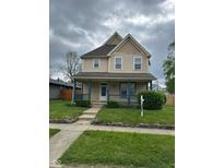 Charming two-story home with a welcoming porch and well-manicured lawn at 2605 Carrollton Ave, Indianapolis, IN 46205