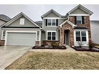 Charming two-story home featuring a brick and siding exterior, a two-car garage, and a well-manicured front lawn at 4114 Spirea Dr, Plainfield, IN 46168