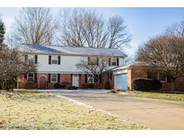 Charming two-story home featuring a brick facade, white siding, and a well-maintained front yard at 523 Memory Ln, Carmel, IN 46032